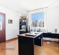 Iroda számítógéppel, polccal és ablakkal, függőleges redőnyökkel az üzleti helyiségben.