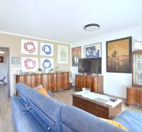 Nappali egy háromszobás lakásban fa dekor padlóval és stílusos bútorokkal.