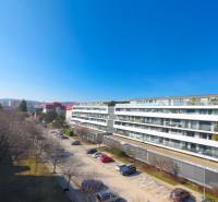 Lakókomplexum a Pri vinohradoch utcában Pozsony-Rača városrészben, kilátás a parkra és a parkolóra.