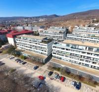 Lakóházak a Pri vinohradoch utcában, Pozsony-Rača városrészben, zölddel és dombokkal körülvéve.