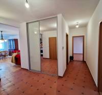 Folyosó csempével, beépített szekrénnyel és nappaliba vezető bejárattal egy 4 szobás lakásban.