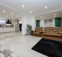 Nappali egy családi házban ülőgarnitúrával és konyhai térrel.