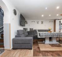 Nappali sarokkanapéval, asztallal és fa dekorációjú padlóval egy családi házban.