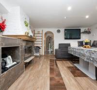 Nappali kandallóval, ülőgarnitúrával és asztallal; fa dekorációjú padló.