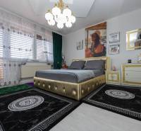 Hálószoba családi házban kárpitozott ággyal és díszes függönyökkel.