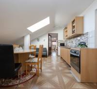 Konyha családi házban étkezőasztallal, fa dekoros padlóval.