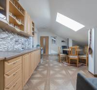 Családi ház konyhája fa dekoros padlóval és nyeregtetős tetőablakkal.