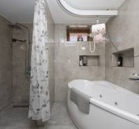 Fürdőszoba zuhanyzóval és káddal családi házban, falak kerámia burkolattal.