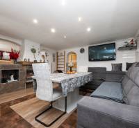 Nappali egy családi házban kényelmes kanapéval és fa dekorációjú padlóval.