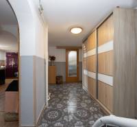 Folyosó csempével, beépített szekrénnyel és boltíves átjáróval a családi házban.