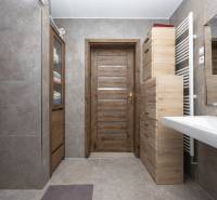 Fürdőszoba családi házban fa dekorációval és kerámia burkolatokkal.