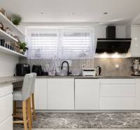 Konyha családi házban fehér bútorokkal, dekoratív polcokkal és stílusos készülékekkel.