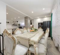 Étkezőasztal és székek egy családi házban gazdagon díszített dizájnnal.