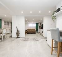 Családi ház belső tere étkezővel, nappali résszel és fa dekorációjú padlóval.