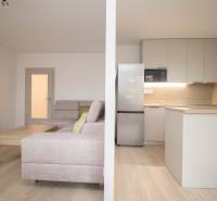 Nappali konyhával és fa dekoros padlóval egy háromszobás lakásban.