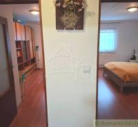 Családi ház belső tere fa dekorációjú padlóval, hálószoba és tárolóhely.