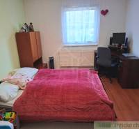 Hálószoba családi házban ággyal, íróasztallal és fa dekoros padlóval.