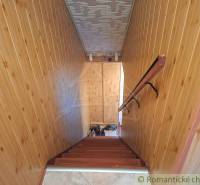 Családi ház belső tere fa burkolatú falakkal és fa dekorációjú lépcsővel.