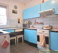 Konyha családi házban kék szekrényekkel és csempézett fallal.