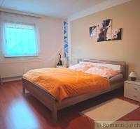 Hálószoba családi házban ággyal, dekorációval és fa dekoros padlóval.