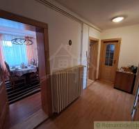 Folyosó fa mintázatú padlóval egy családi házban, hangulatos bútor elrendezés.