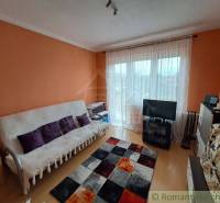 Nappali egy családi házban, fa dekorációjú padlóval és narancssárga falakkal.