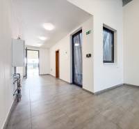 Egy üzlethelyiség belső tere csempézett padlóval és üvegajtókkal.