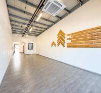 Kereskedelmi helyiségek fa mintázatú padlóval és faldekorációval.