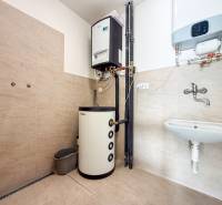 Kereskedelmi helyiségek belső tere fűtési rendszerrel, mosdóval és fa dekorációjú padlóval.