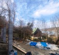 Építőanyag a Zajačia debra melletti házikó mellett Holčíkovce-ben, kilátással a vízfelületre.