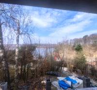 Kilátás a tóra a Holčíkovce-i Nyúlvölgyi Faházból, amelyet erdő vesz körül.