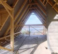 Egy építés alatt álló házikó belső tere kilátással a természetre, fa dekorációjú padlóval.