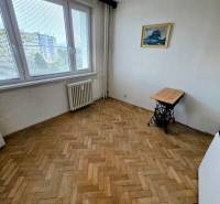 Szoba fa dekor padlóval egy háromszobás lakásban, képpel és asztallal.