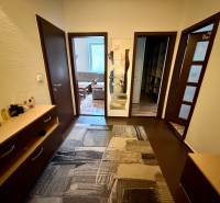 A háromszobás lakás előszobája fa dekor padlóval és szőnyeggel.