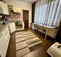 Konyha egy 3 szobás lakásban sötét padlóval és nagy ablakkal.