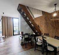 Ház fa dekor padlóval, lépcsővel és asztallal a fa lamellás fal mellett.