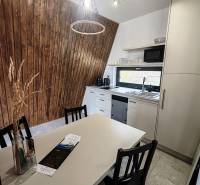 Konyha fahatású padlóval, fa falakkal és modern felszereléssel rendelkező házikóban.