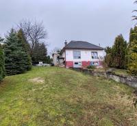 Családi ház a Fő utcán, Piskorócon, fákkal körülvéve és füves udvarral.