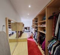 Gardrób családi házban piros szőnyeggel és beépített polcokkal.