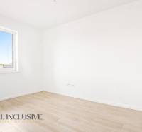 Üres szoba fehér falakkal és fa dekorációjú padlóval egy háromszobás lakásban.