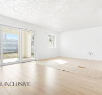 Világos nappali egy háromszobás lakásban, fa dekorációjú padlóval.