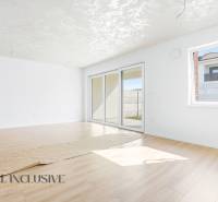 3 szobás lakás fehér falakkal és fa mintázatú padlóval.