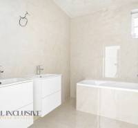 Fürdőszoba két mosdóval és káddal egy háromszobás lakásban.