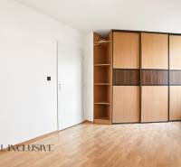 Fehér belső tér nagy szekrénnyel és fa dekorációjú padlóval egy kétszobás lakásban.