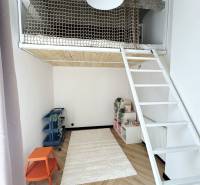 Gyerekszoba egy háromszobás lakásban emeletes ággyal és fa dekor padlóval.