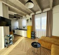 Nappali egy háromszobás lakásban fa dekorációjú padlóval és sárga hűtőszekrénnyel.