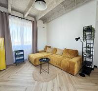 Nappali fa hatású padlóval, sárga kanapéval és retro hűtőszekrénnyel.