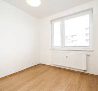 Szoba egy kétszobás lakásban fa dekoros padlóval és ablakkal, radiátorral.