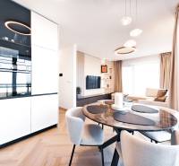 Kétszobás lakás étkezőasztallal, kanapéval és fa dekorációjú padlóval.