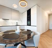Étkező sarok márvány asztallal és konyhával egy kétszobás lakásban, fa dekorációjú padlóval.